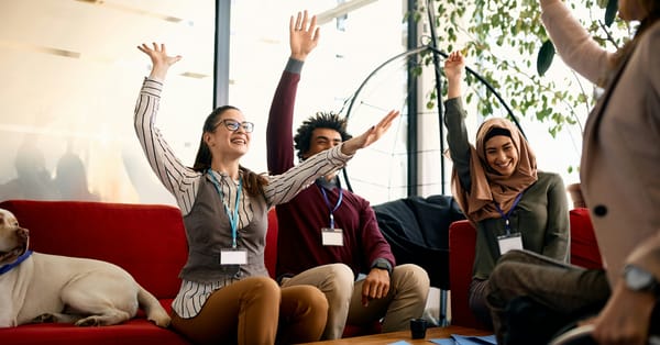 Happy coworkers celebrating success in a modern workplace environment.